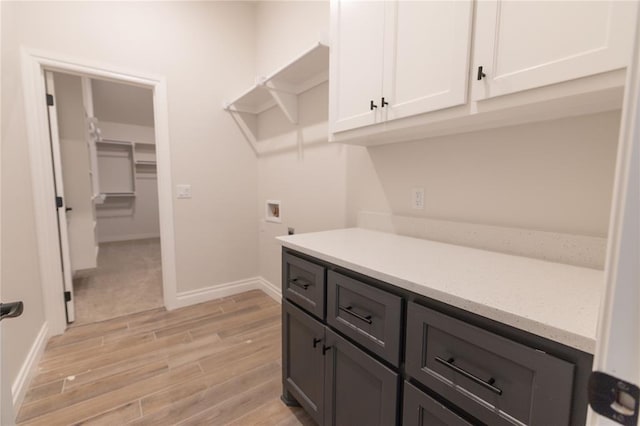 clothes washing area featuring hookup for a washing machine and cabinets