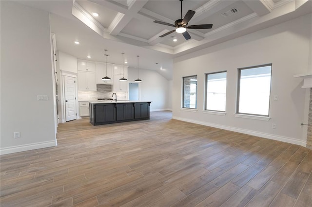 unfurnished living room featuring coffered ceiling, ceiling fan, crown molding, and beamed ceiling