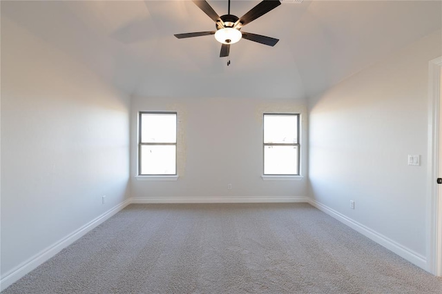 carpeted spare room featuring ceiling fan, lofted ceiling, and plenty of natural light