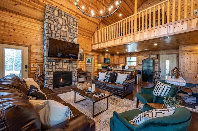 living room with wooden walls, light hardwood / wood-style flooring, high vaulted ceiling, wooden ceiling, and a stone fireplace