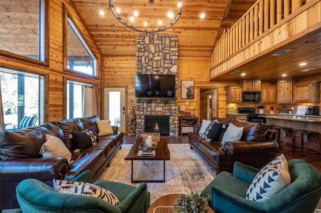 living room with wooden walls, an inviting chandelier, high vaulted ceiling, wooden ceiling, and a stone fireplace