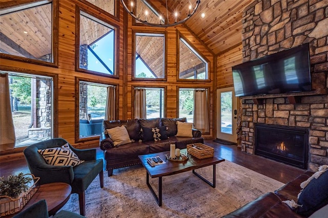 living room featuring wood walls, wooden ceiling, a fireplace, and high vaulted ceiling