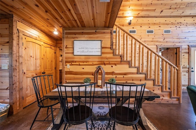 dining room featuring wooden ceiling and wooden walls