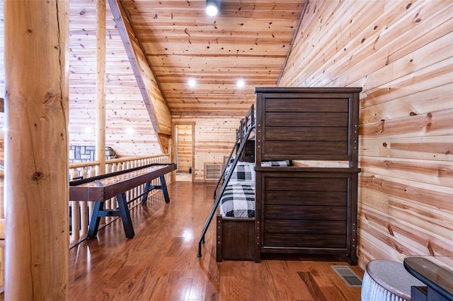 bedroom with hardwood / wood-style floors, wood walls, wood ceiling, and vaulted ceiling