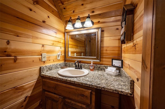 bathroom featuring vanity, lofted ceiling, and wood walls