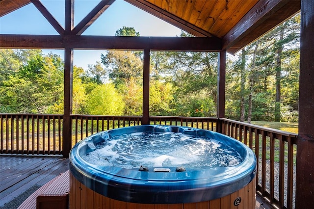 sunroom with a jacuzzi, a wealth of natural light, and lofted ceiling