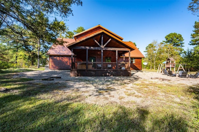 rear view of property featuring a porch and a playground