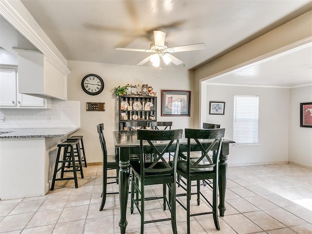 dining room with ceiling fan, crown molding, and light tile patterned floors