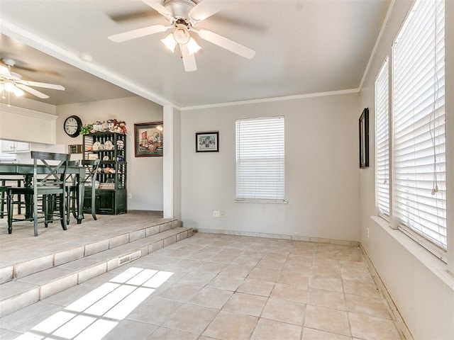 spare room with ceiling fan, ornamental molding, and light tile patterned floors