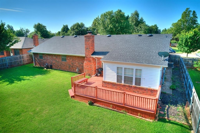 rear view of house with a yard, central AC, and a wooden deck