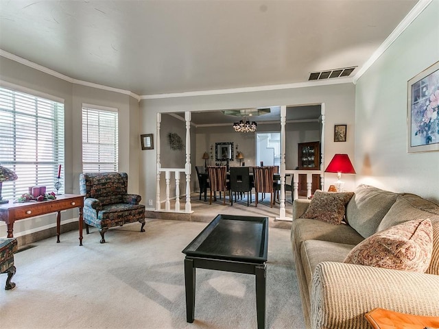 living room featuring a chandelier, light colored carpet, decorative columns, and ornamental molding