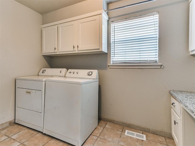 laundry room featuring cabinets and washing machine and dryer