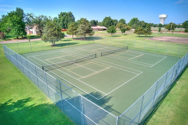 view of tennis court with a yard