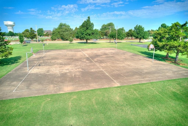 view of property's community with basketball hoop and a yard