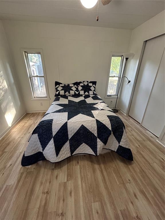 bedroom featuring light hardwood / wood-style flooring and multiple windows