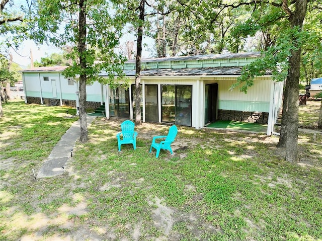 rear view of property with a yard