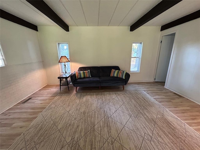 living room featuring beam ceiling and light hardwood / wood-style flooring