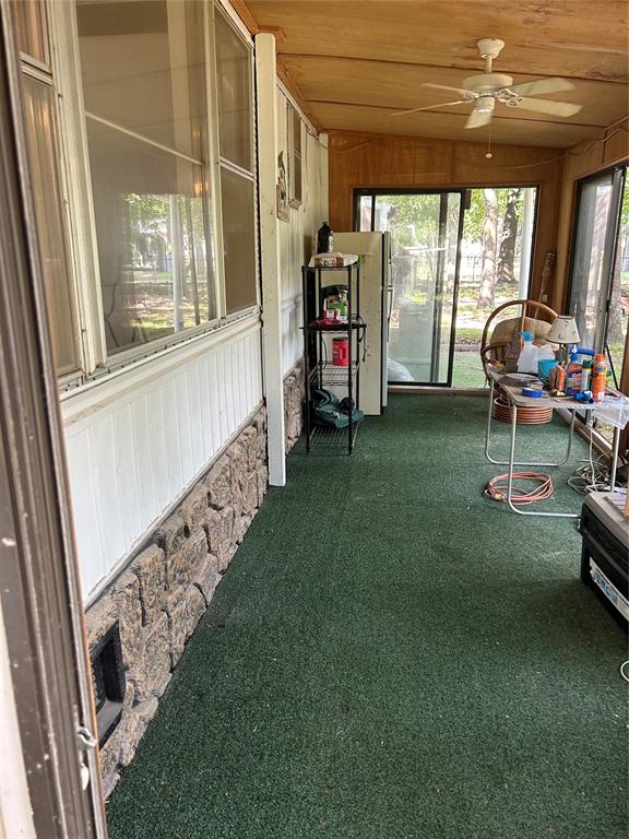 sunroom / solarium with ceiling fan, wooden ceiling, and vaulted ceiling