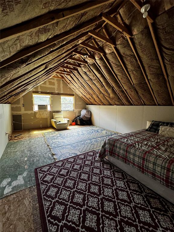 unfurnished bedroom featuring cooling unit and vaulted ceiling