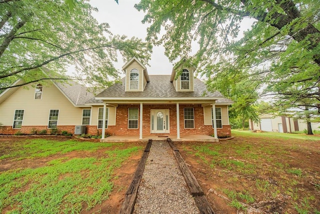 new england style home with covered porch and a front lawn