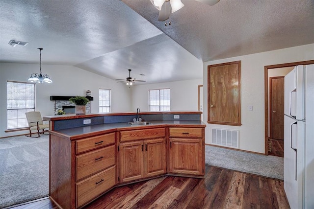 kitchen featuring vaulted ceiling, dark wood-type flooring, sink, pendant lighting, and white refrigerator