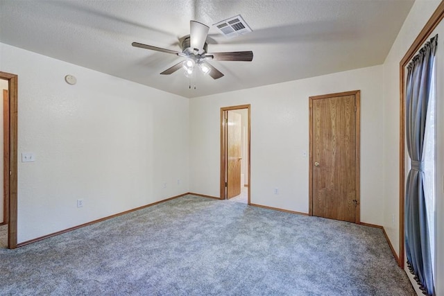 unfurnished bedroom with carpet flooring, ceiling fan, a closet, and a textured ceiling