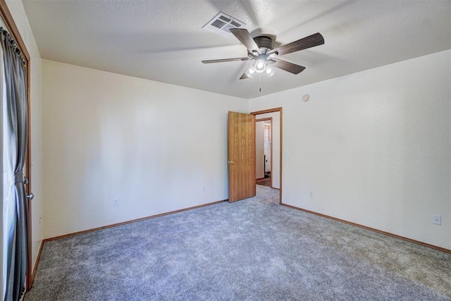 unfurnished room with carpet, ceiling fan, and a textured ceiling