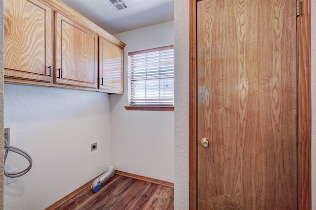 laundry area with hookup for an electric dryer, dark hardwood / wood-style flooring, and cabinets