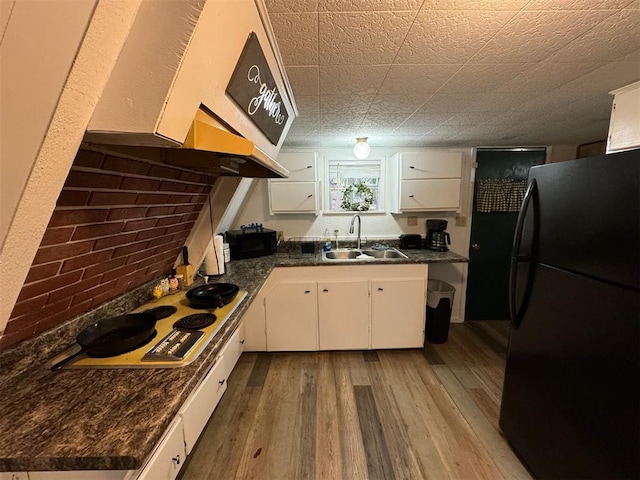 kitchen featuring sink, light hardwood / wood-style flooring, white cabinetry, and black appliances