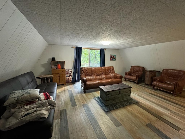 living room featuring lofted ceiling and light hardwood / wood-style flooring