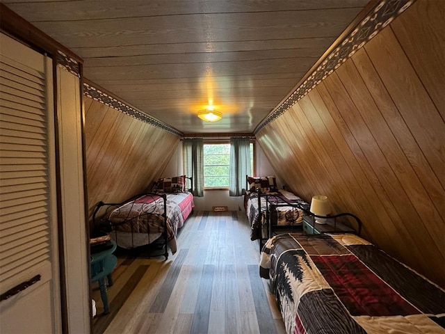 bedroom with hardwood / wood-style floors, vaulted ceiling, wooden ceiling, and wood walls