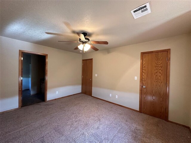 carpeted empty room featuring a textured ceiling and ceiling fan