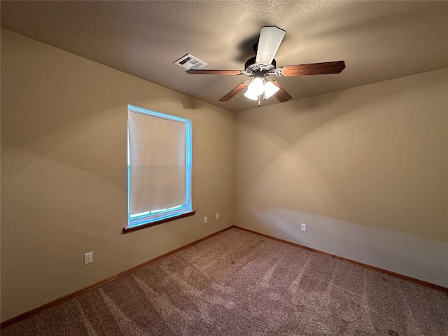 carpeted spare room with ceiling fan and a textured ceiling