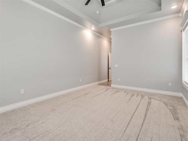 unfurnished room with ceiling fan, ornamental molding, a raised ceiling, and light carpet