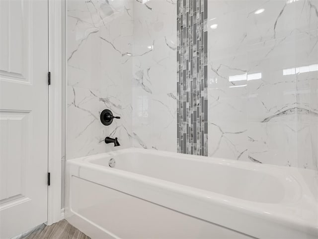 bathroom with tiled shower / bath combo and hardwood / wood-style flooring