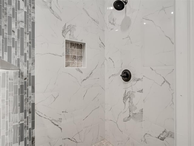 interior details featuring tiled shower