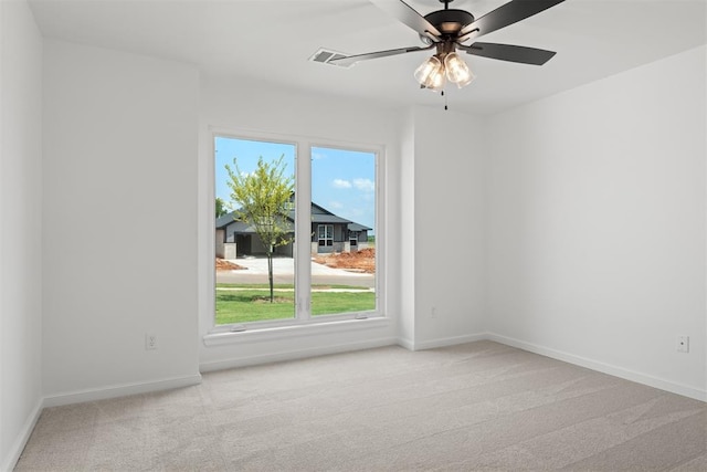 unfurnished room with light colored carpet, plenty of natural light, and ceiling fan