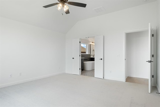 unfurnished bedroom featuring ceiling fan, lofted ceiling, light carpet, and connected bathroom