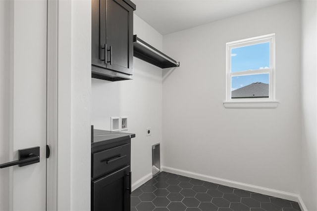 laundry area featuring hookup for an electric dryer, hookup for a washing machine, dark tile patterned floors, and cabinets