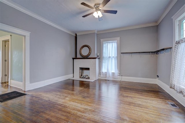 unfurnished living room with hardwood / wood-style floors, ceiling fan, ornamental molding, and a brick fireplace