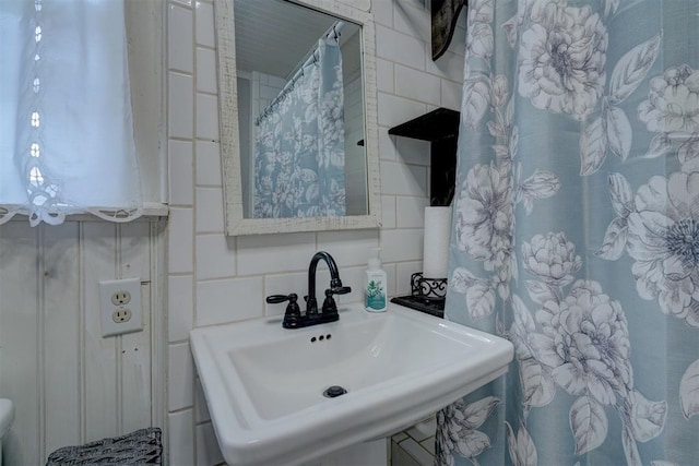 bathroom with tile walls and sink