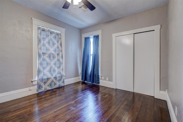 unfurnished bedroom featuring ceiling fan, a closet, and dark hardwood / wood-style floors