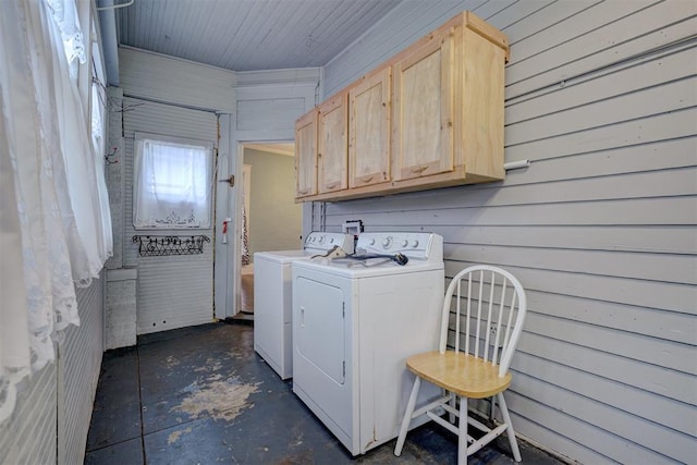 washroom featuring cabinets, separate washer and dryer, and wood walls