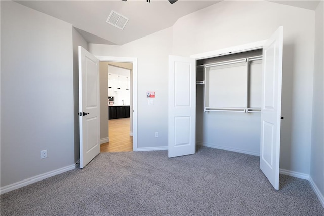 unfurnished bedroom with a closet, ceiling fan, carpet flooring, and lofted ceiling