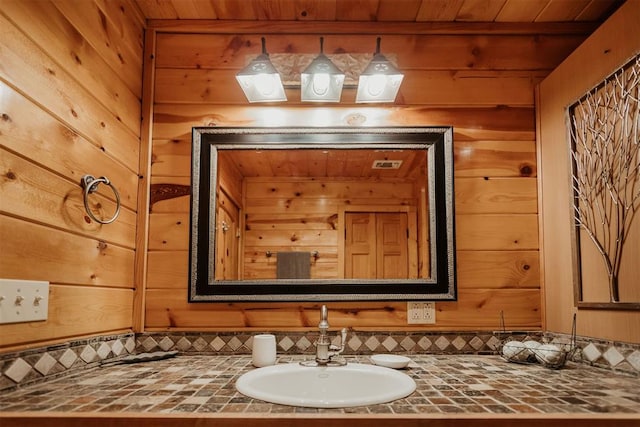 bathroom featuring vanity, wood ceiling, wooden walls, and tasteful backsplash