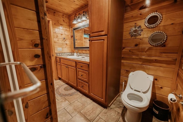 bathroom featuring wood walls, vanity, wooden ceiling, and toilet