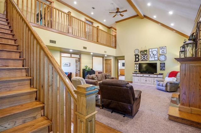 carpeted living room with ceiling fan, beamed ceiling, high vaulted ceiling, and crown molding