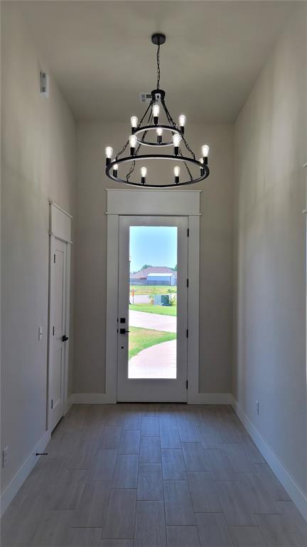 1425 W Harvard Way, Mustang, OK 73064 - foyer with a chandelier and baseboards