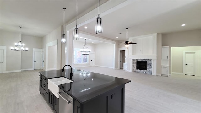 1425 W Harvard Way, Mustang, OK 73064 - kitchen with a sink, open floor plan, a chandelier, a stone fireplace, and a ceiling fan