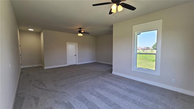 spare room featuring dark colored carpet and ceiling fan